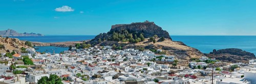 Panoramic view over the coastal landscape of Lindos with Acropolis and hills in the background,