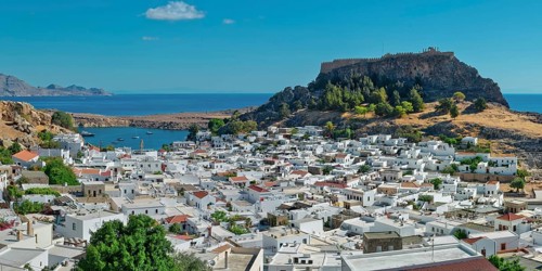 The picturesque town of Lindos with acropolis with white buildings near the coast, overlooked from