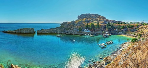 Panoramic view of the calm Paulus Bay of Lindos with turquoise-coloured water, surrounded by