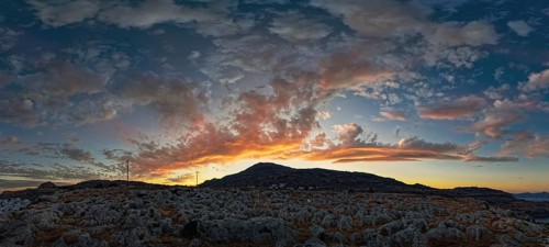 Dramatic landscape of Lindos with a mountain in the background and colourful sunset in the sky,