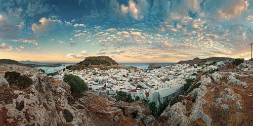 Panoramic view of the Greek town of Lindos by the sea with Acropolis at sunset with dramatic sky