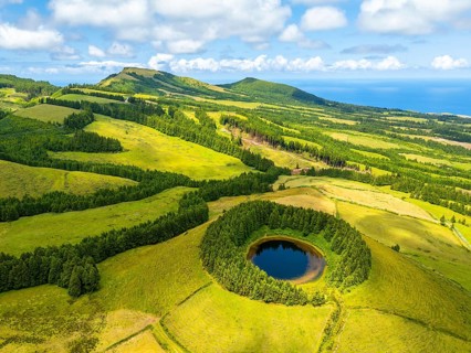Lake Pau Pique and Lush Green Hills with Pastureland and Trees. Shadows of Clouds. Atlantic Ocean.
