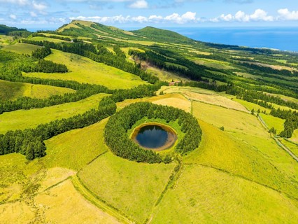 Lake Pau Pique and Lush Green Hills with Pastureland and Trees. Atlantic Ocean. Azores, Sao Miguel