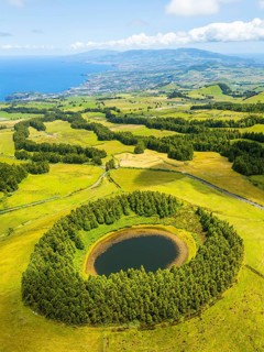 Pond Pau Pique and Lush Green Hills with Pasturelands. Atlantic Ocean. Azores, Sao Miguel Island.