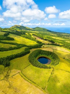 Pond Pau Pique and Lush Green Hills with Pastureland and Trees. Shadows of Clouds. Atlantic Ocean.