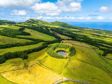 Pond Pau Pique and Lush Green Hills with Pastureland and Trees. Shadows of Clouds. Atlantic Ocean.