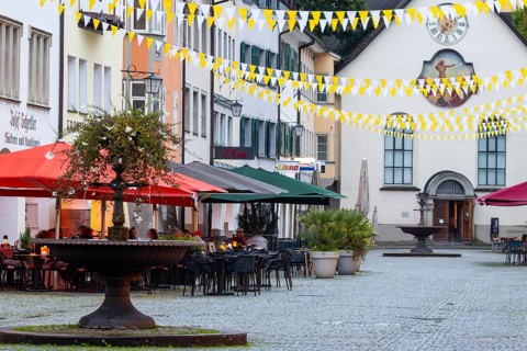 Fountain, outdoor seating at a restaurant, parasols, St John's Church, market square, Feldkirch,