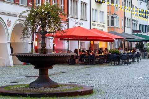 Fountain, outdoor seating of a restaurant, sunshades, market square, Feldkirch, Vorarlberg, Austria