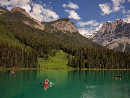 A group canoeing on Emerald Lake with the dramatic Canadian Rocky Mountains as a scenic backdrop
