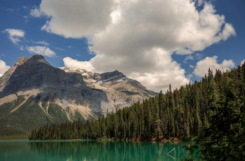 The Canadian Rocky Mountains with clouds above Emerald and dense forest inside Yoho National Park,
