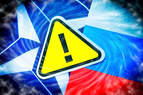 The flags of NATO and Russia with danger sign, photomontage