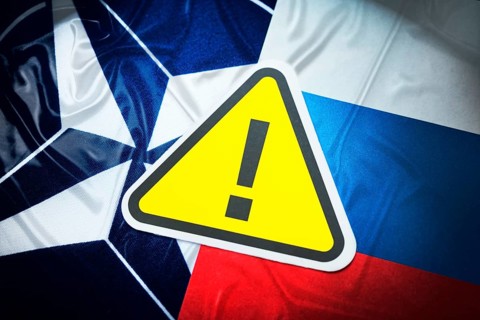 The flags of NATO and Russia with danger sign
