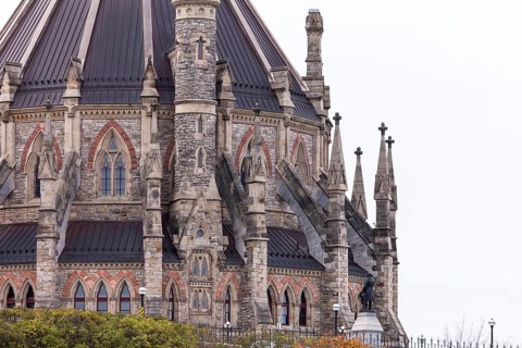 A detailed view of a gothic-style stone building of the Canadian Parliament Buildings with