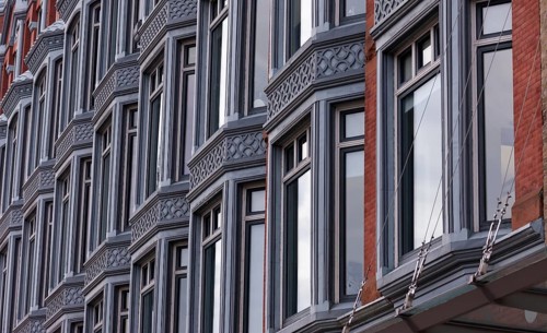 Close-up of a building facade with multiple windows and ornate architectural details, featuring a
