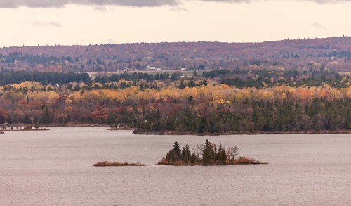 The Ottawa River with small islets surrounded by colorful autumn trees and hills in Ottawa,