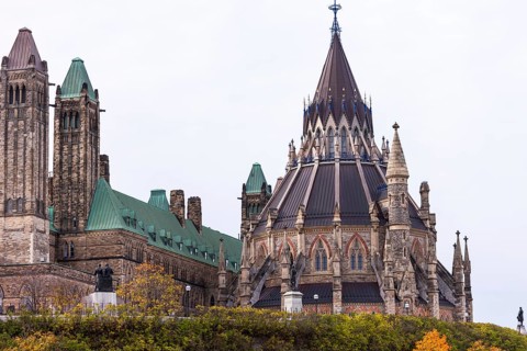 The Canadian Parliament Buildings with Gothic architecture, featuring towers and a prominent spire