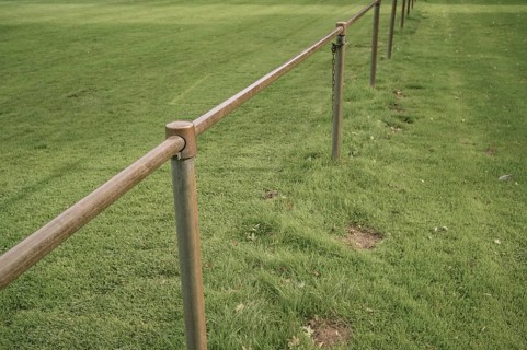 Borken, NRW, Germany, Metal railing creating a barrier along the edge of a lush green grass field