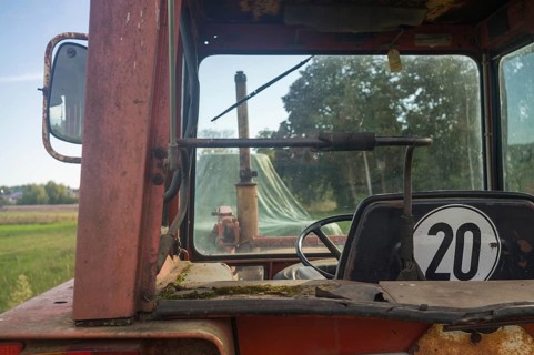 Borken, NRW, Germany, View from inside an old rusty tractor cab looking out at a green farm field