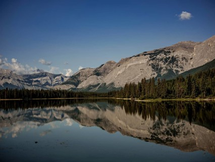 Scenic view of mountains of the Canadian Rocky Mountains mirrored in a still lake on a clear day