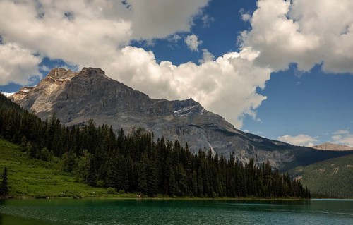 The Canadian Rocky Mountains and forests framing Emerald Lake with a sky full of clouds inside Yoho