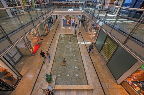 Shops and fountain with frog king in Forum Allgäu, Kempten, Allgäu, Swabia, Germany
