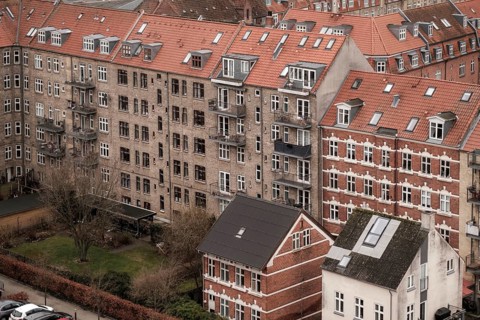 Dense urban scene with red tile roofed residential buildings under an overcast sky in Aarhus,
