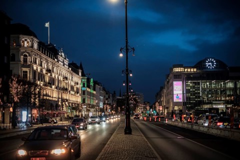 A vibrant city street in the evening with glowing lights and historic buildings in Helsingborg,