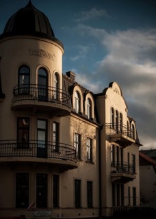 Sunlit historic European building with dramatic shadows against a cloudy sky in Helsingborg,