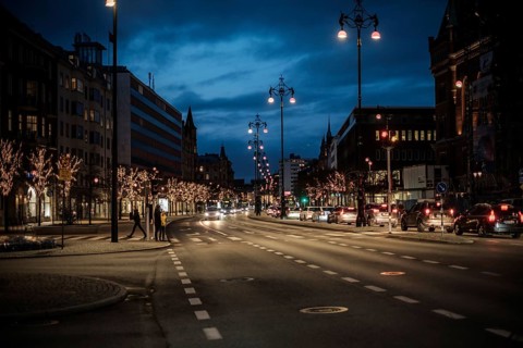 Nighttime urban road lined with illuminated trees and passing cars in Helsingborg, Sweden,