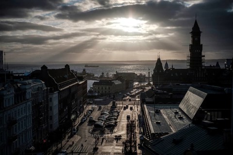 A dramatic city view with a silhouette against a sunset over the Oresund Strait, between Sweden and