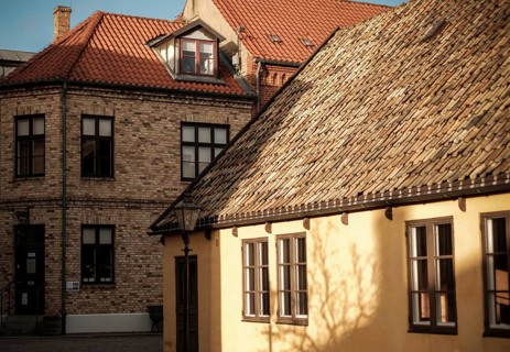 Buildings with contrasting rooftops and sunlight casting shadows, an urban architectural scene in