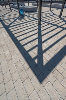 Concrete pavement, blue rubbish bin, long shadows at the state vocational school, Kempten, Allgäu,
