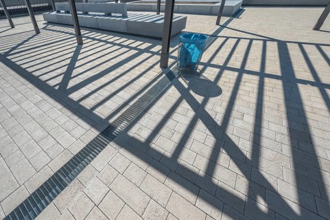 Concrete pavement, blue rubbish bin, long shadows at the state vocational school, Kempten, Allgäu,