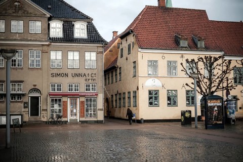 Daytime scene with historic buildings lining an empty cobblestone square in Helsingor, Denmark,