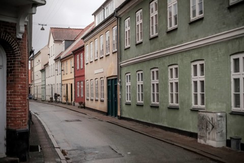A quiet street with colorful houses and overcast skies in Helsingor, Denmark, Northern Europe