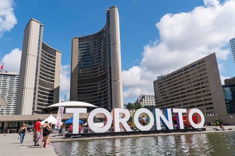 Toronto sign in front of Toronto City Hall with a bright blue sky in Toronto, Ontario, Canada,