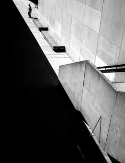Geometric black and white scene with sharp shadows and a solitary person against a wall in Toronto,