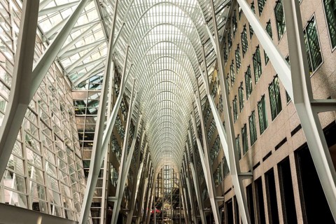 Modern interior of Brookfield Place with a glass ceiling and steel arches creating a symmetrical