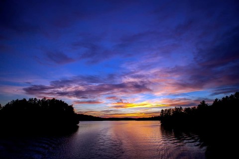 Serene lake at sunset with colorful sky reflections creating a peaceful landscape in Muskoka,