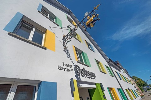 Blue sky, Hotel-Gasthof-Ochsen with nose sign and colourful windows in Kisslegg, Allgäu,