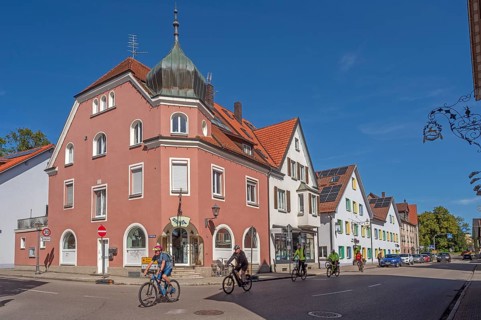 Blue sky, street with cyclists, pointed gable houses and ZAPPA BAR in Kisslegg, Allgäu,