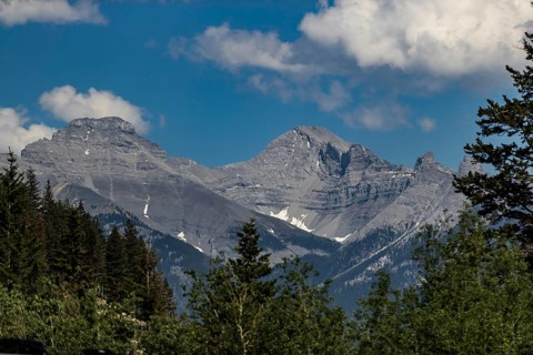 Rocky mountain peaks under a blue sky with clouds inside Yoho National Park in British Columbia,