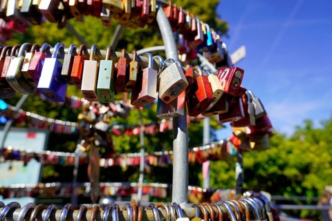 Several colourful padlocks attached to a metal frame outdoors, Nuremberg, Middle Franconia,