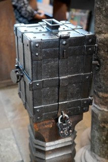 An antique metal box with a lock on a wooden floor, rustic and historic in appearance, St. Lawrence