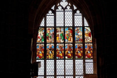 Large stained glass window depicting religious scenes in a Gothic church, Church of St. Lawrence,