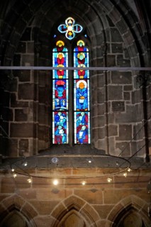 Stained glass window with artistic depictions in a Gothic church, Church of St. Lawrence,