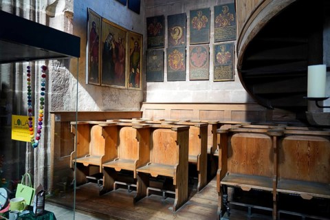 Wooden benches and religious wall decorations in a Gothic church, St Lorenz Church, Nuremberg,