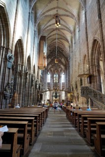 Long nave with high Gothic vaults and people exploring the space, St. Lawrence Church, Nuremberg,