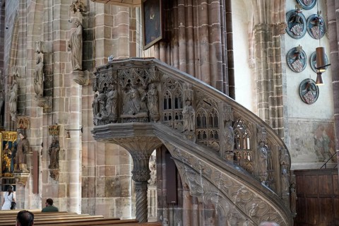 Detail of an ornately carved pulpit in an old church with depictions and figures, Church of St