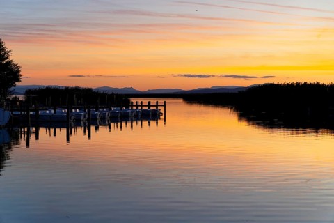 Lake Neusiedl, Burgenland, Austria, Europe, A lake at sunset with quiet boats and a jetty in the